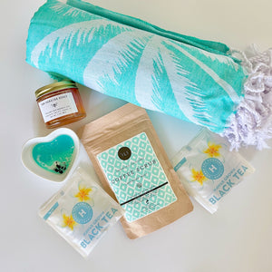 Various gift items including raw honey, beach towel, tea, coffee scrub